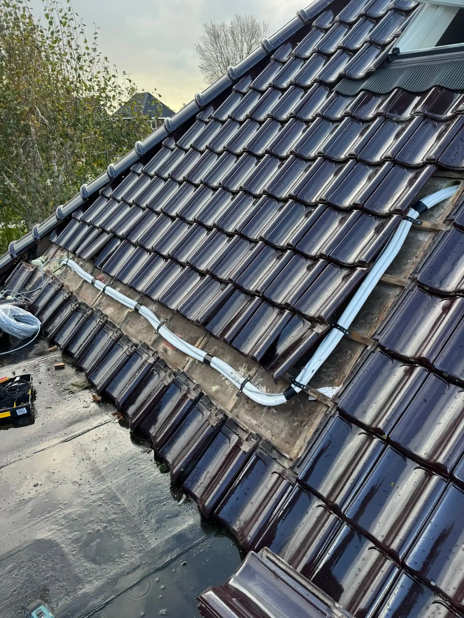 Leidingwerk en dakdoorvoer van een warmtepomp- of airco-installatie